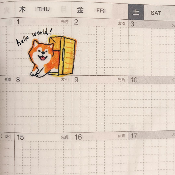 A photo of a calendar, with a shiba inu sticker. The text reads 'Hello World!'